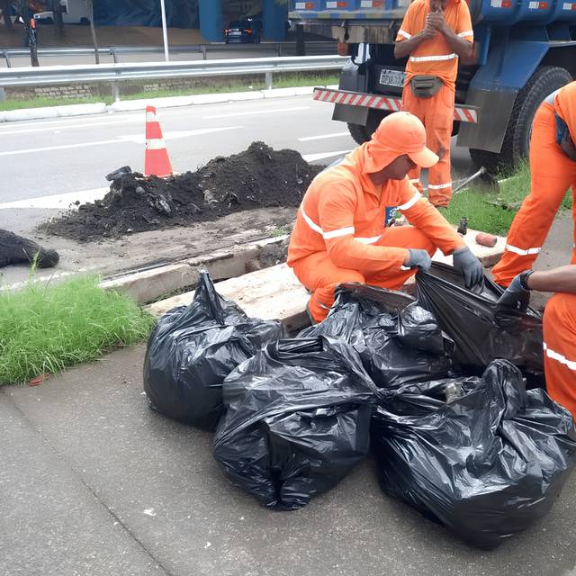 Sacos de lixo coletados manualmente em limpeza urbana